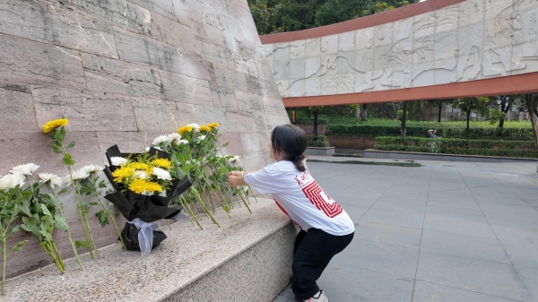 屈美芸在烈士纪念碑前献花。taptap点点官方网站美术学院供图