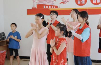 志愿者与小朋友一起跳手势舞。taptap点点官方网站供图
