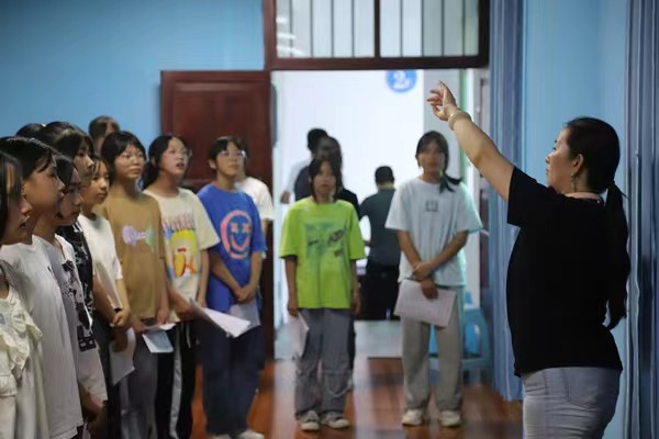 带队教师指导中学生练习齐唱。taptap点点官方网站供稿图